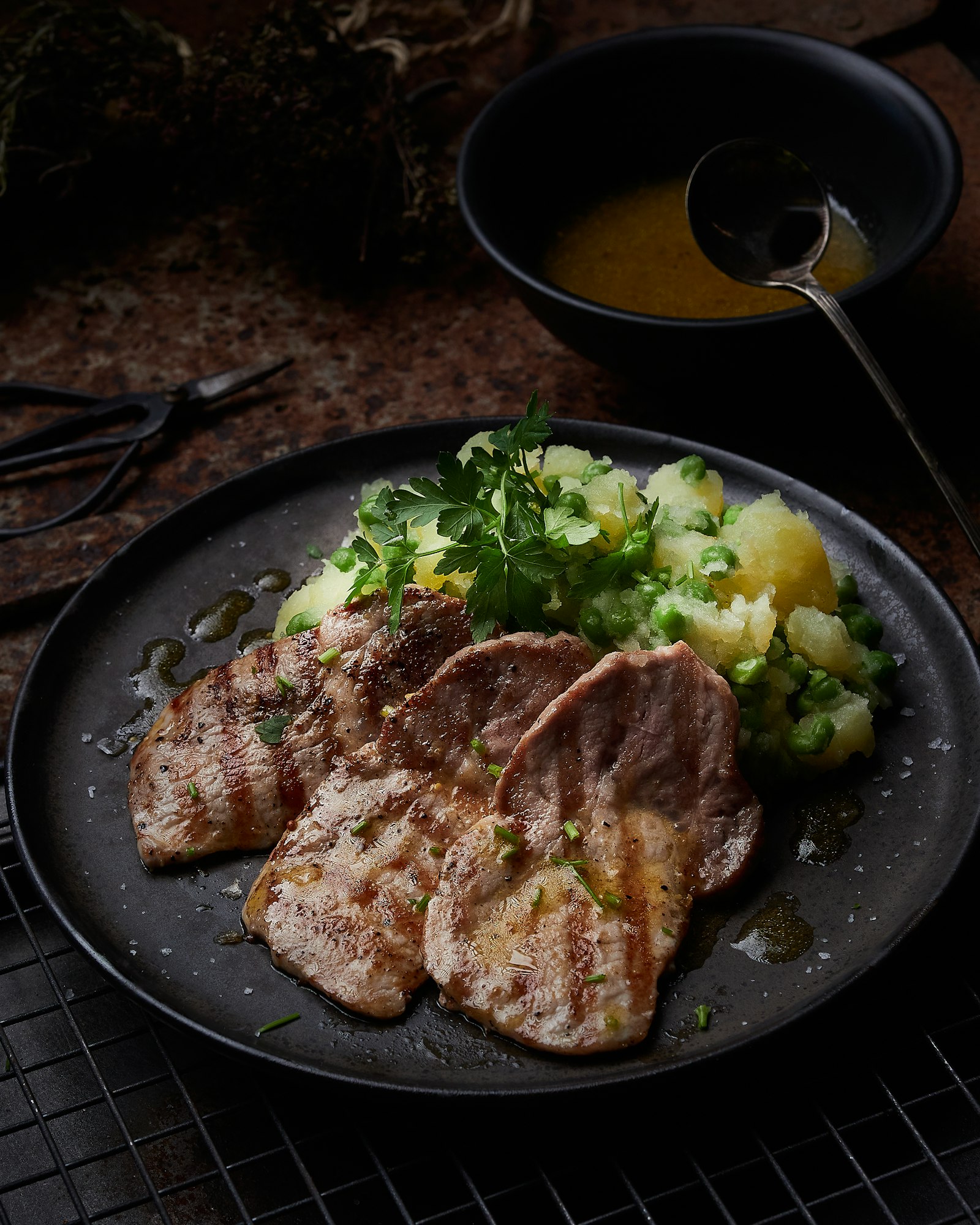 three grilled pork tenderloin steaks on black plate
